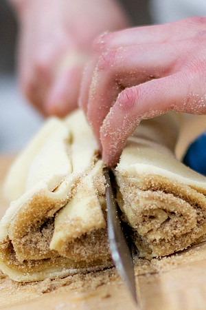 Cutting into cinnamon rolls.